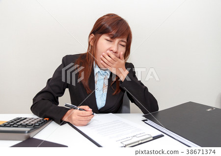 Businesswoman yawn or feel sleepy while working Businesswoman yawn or feel sleepy while working 38671374