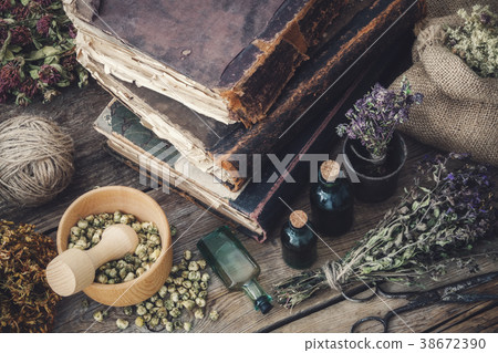 Tinctures, assortment of dry herbs and old books. Tinctures, assortment of dry herbs and old books. 38672390