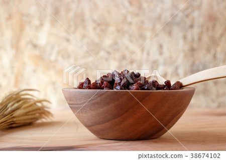 Raisin in bowl on wooden background. Raisin in bowl on wooden background. 38674102