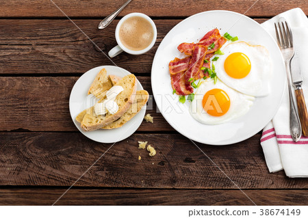 Fried eggs, bacon and italian ciabatta bread Fried eggs, bacon and italian ciabatta bread 38674149