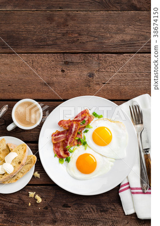 Fried eggs, bacon and italian ciabatta bread Fried eggs, bacon and italian ciabatta bread 38674150