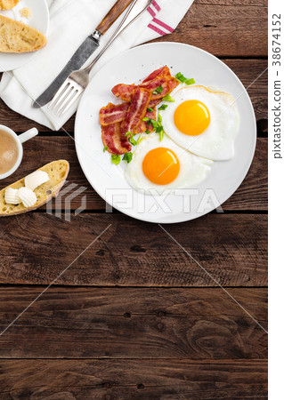 Fried eggs, bacon and italian ciabatta bread Fried eggs, bacon and italian ciabatta bread 38674152