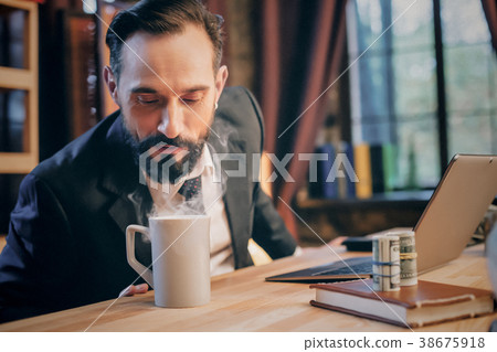 Portrait of mature man sitting at his desk in the 38675918
