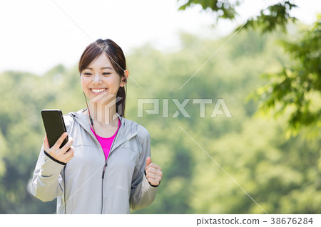 A woman listening to music on a smartphone A woman listening to music on a smartphone 38676284