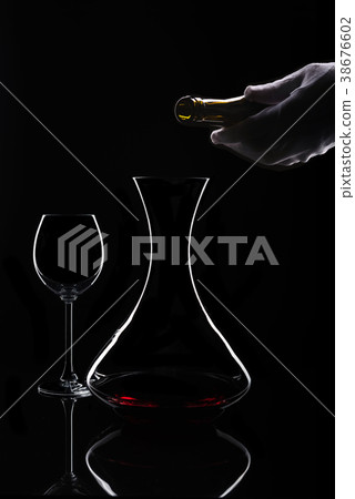 Red wine decanting process at isolated black Red wine decanting process at isolated black 38676602