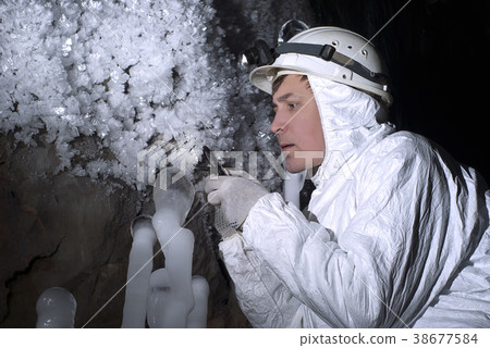 the cave explorer looks at the icy stalagmite.. the cave explorer looks at the icy stalagmite.. 38677584