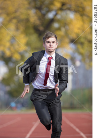 Young businessman in suit running on track 38682291