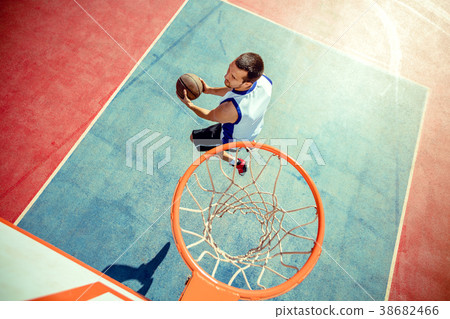High angle view of basketball player dunking High angle view of basketball player dunking 38682466