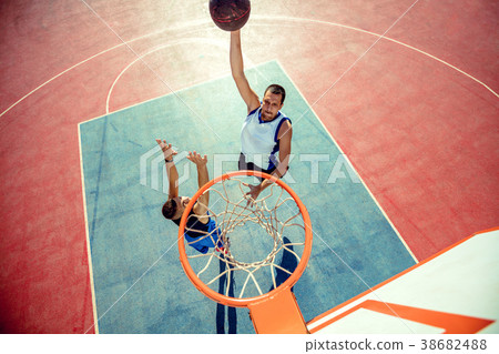 High angle view of basketball player dunking High angle view of basketball player dunking 38682488