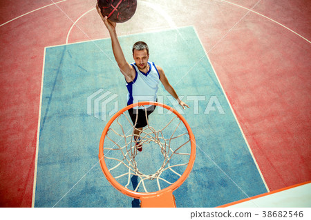 High angle view of basketball player dunking High angle view of basketball player dunking 38682546