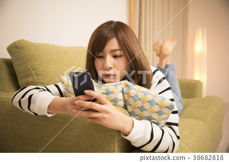 躺下來看智能手機的女人 躺下來看智能手機的女人 38682818