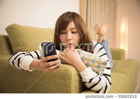 躺下來看智能手機的女人 38682819