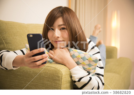 躺下來看智能手機的女人 躺下來看智能手機的女人 38682820