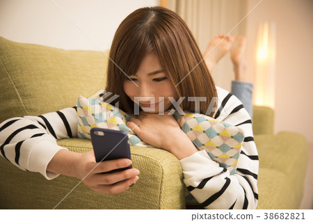 躺下來看智能手機的女人 躺下來看智能手機的女人 38682821
