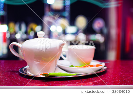 Black tea in a ceramic teapot on a tray with a cup Black tea in a ceramic teapot on a tray with a cup 38684010