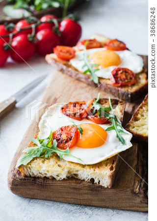 Breakfast toast with egg, arugula and roasted Breakfast toast with egg, arugula and roasted 38686248