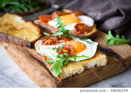 Healthy breakfast toast with egg, roasted tomato Healthy breakfast toast with egg, roasted tomato 38686249