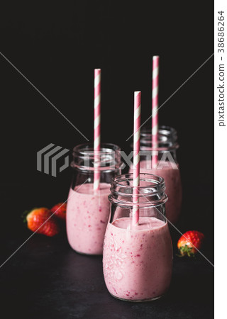 Fresh strawberry smoothies in jars with pink Fresh strawberry smoothies in jars with pink 38686264