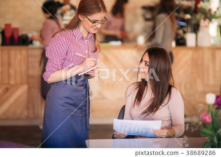 Hospitable waitress with notepapers and pencil 38689286