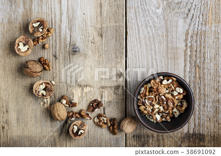 Walnut kernels in a  bowl and whole walnuts  38691092