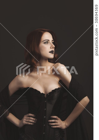 Young redhead woman in black corset Young redhead woman in black corset 38694369