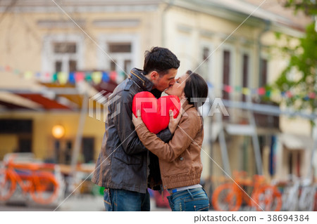 Young couple with heart shape toy kissing 38694384