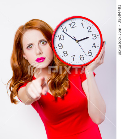 Surprised redhead girl in red dress with big clock Surprised redhead girl in red dress with big clock 38694493