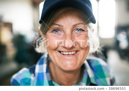 Portrait of a senior female mechanic in a garage. Portrait of a senior female mechanic in a garage. 38696501