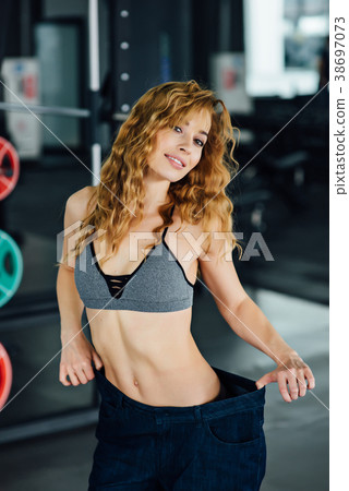 Woman with red hair shows her weight loss. 38697073