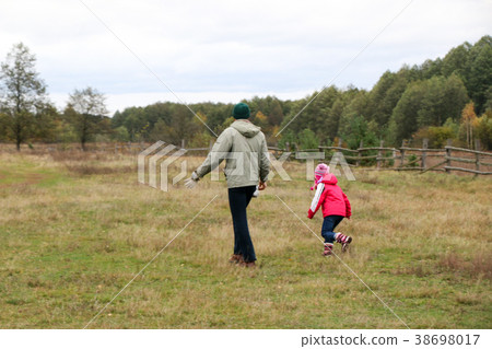Young father playing with his daughter in a field 38698017