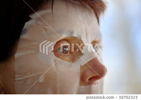 Woman with facial mask sheet 38702323