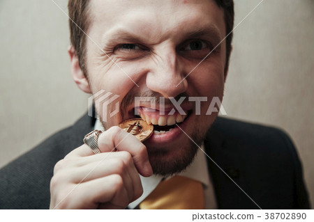 man is trying to break the bitcoin with his teeth 38702890