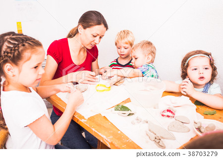 Happy children are engaged with modeling clay Happy children are engaged with modeling clay 38703279