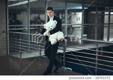 Sad man with a teddy bear awaiting. 38703372