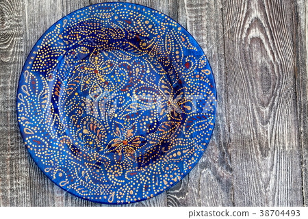 Top view blue hand-painted plate on wooden surface 38704493