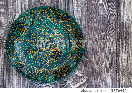 Top view green painted plate on wooden surface Top view green painted plate on wooden surface 38704494