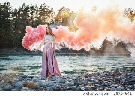 a girl in a long skirt with a smoke bomb in her ha 38704641