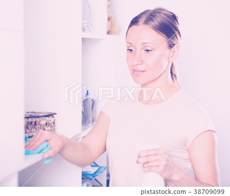 Smiling woman wiping shelves 38709099