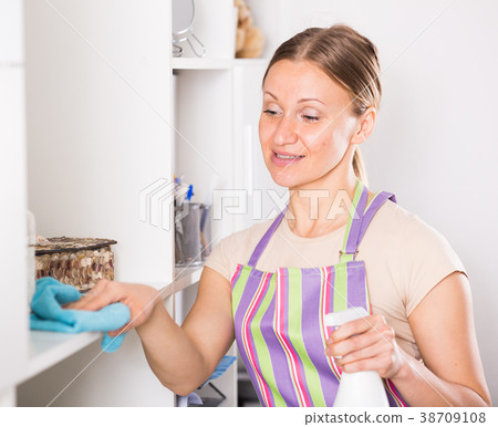 Positive woman wiping shelves 38709108