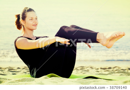 Smiling girl in black T-shirt is practicing yoga 38709140