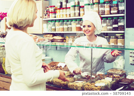 Woman offering female client nuts 38709143