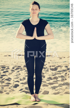 Female in black T-shirt is staying and practicing meditation 38709146
