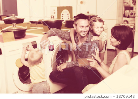 Smiling family with kids shopping modern washer Smiling family with kids shopping modern washer 38709148