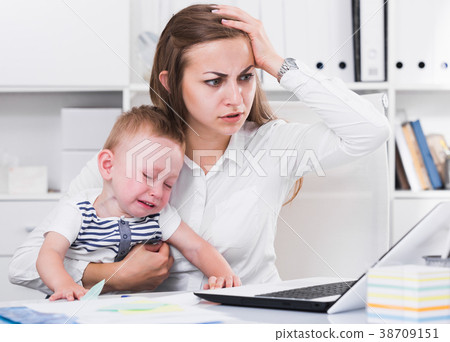 Female employee is working on laptop while child naughty Female employee is working on laptop while child naughty 38709151