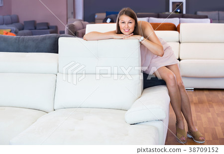 Adult female touching sofa in the furniture store before the buying Adult female touching sofa in the furniture store before the buying 38709152