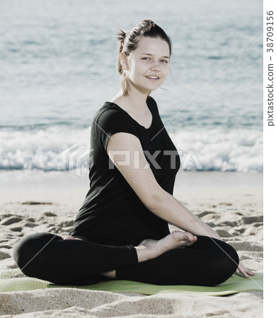 Female 20-30 years old is practicing set of stretching exercises in black T-shirt Female 20-30 years old is practicing set of stretching exercises in black T-shirt 38709156