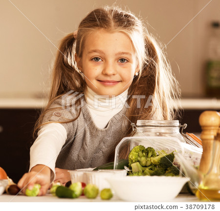 Smiling little girl learning to cook in kitchen 38709178
