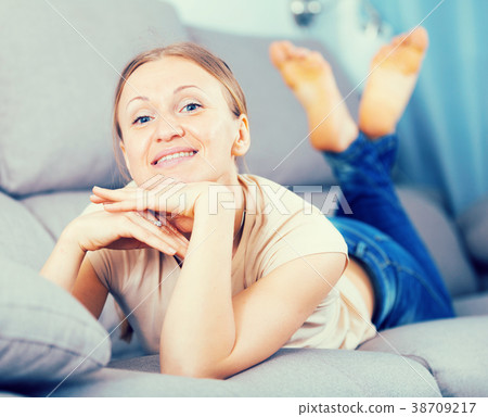 Smiling woman lying on sofa 38709217
