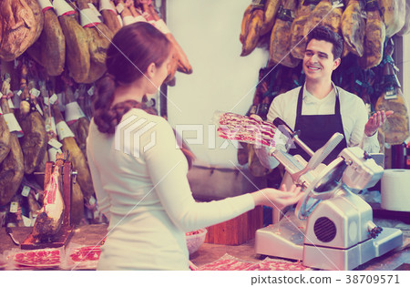 Female customer buying Spanish jamon 38709571