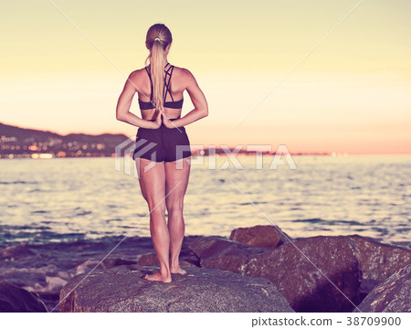 Adult woman is practicing stretching Adult woman is practicing stretching 38709900